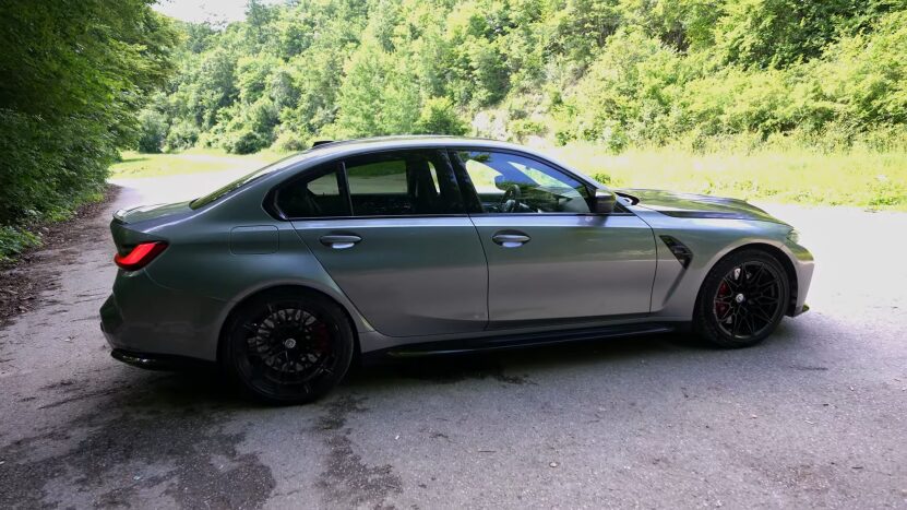 Side View of The 2025 BMW M5 Parked on A Forest Road, Showcasing Its Sleek Design and Larger Dimensions