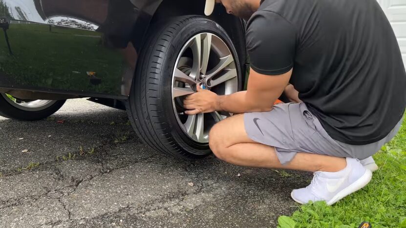 A Person Is Installing Upgraded Wheels and New Tires on A Black BMW