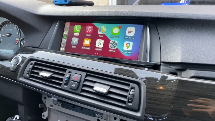 The Image Shows a BMW Infotainment Screen Displaying the Apple CarPlay Interface with Apps Like Music, Maps, Messages, and Google Maps Integrated Seamlessly