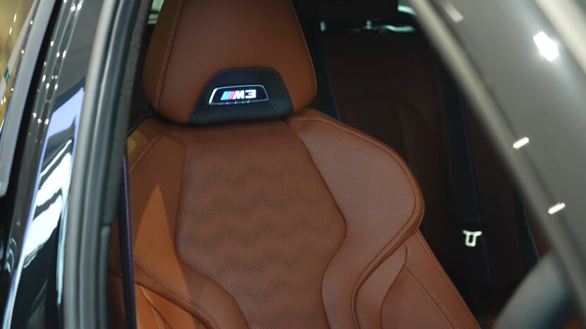 Interior View of The 2025 BMW M3 Showing a Luxurious Brown Leather Sport Seat with An Illuminated M3 Logo on The Headrest