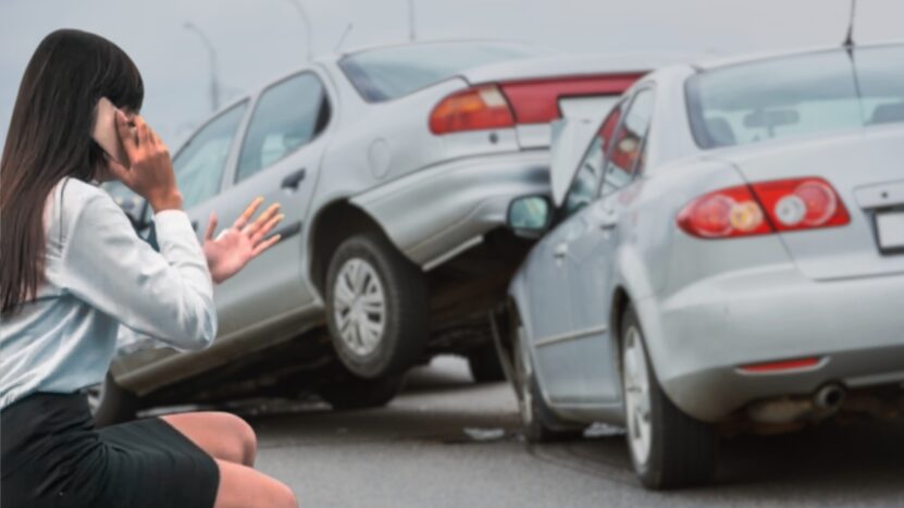 A Woman Is Making a Phone Call While Standing Near Two Cars Involved in A Rear-End Collision