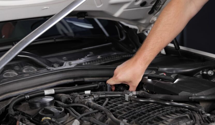 Mechanic repairs BMW drivetrain using tools