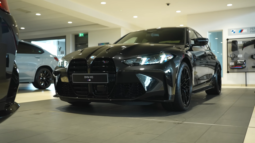 2025 BMW M3 Displayed in A Showroom, Showcasing Its Sleek Black Exterior and Aggressive Front Design