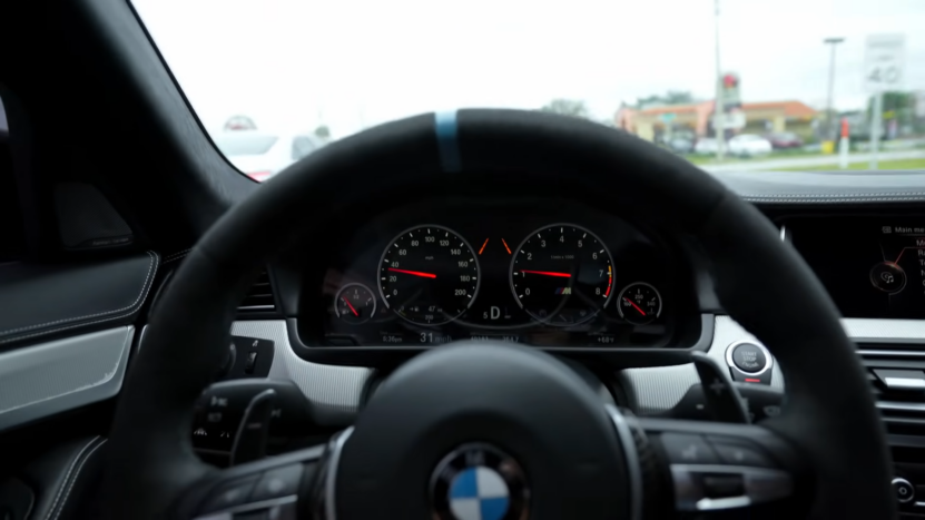 Interior View from The Driver's Seat of A BMW Showing the Dashboard, Steering Wheel, and The Road Ahead