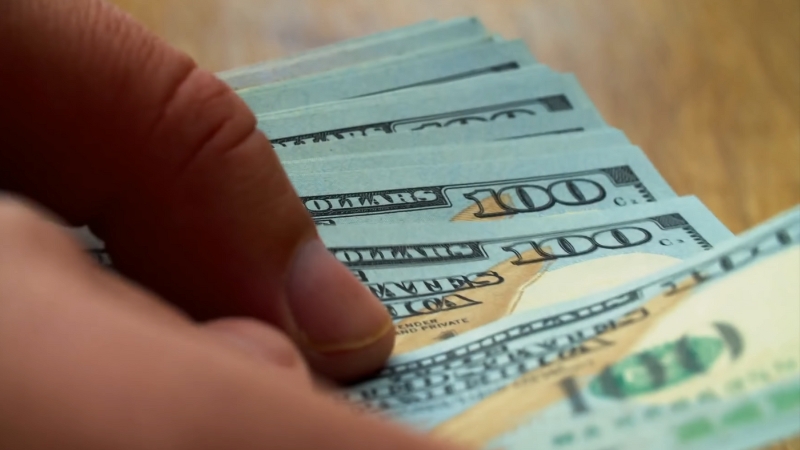 A Person Holds a Stack of Hundred-Dollar Bills, Possibly Preparing for A Car Purchase