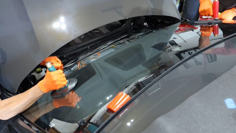 Technicians Carefully Installing a New Windshield on A BMW