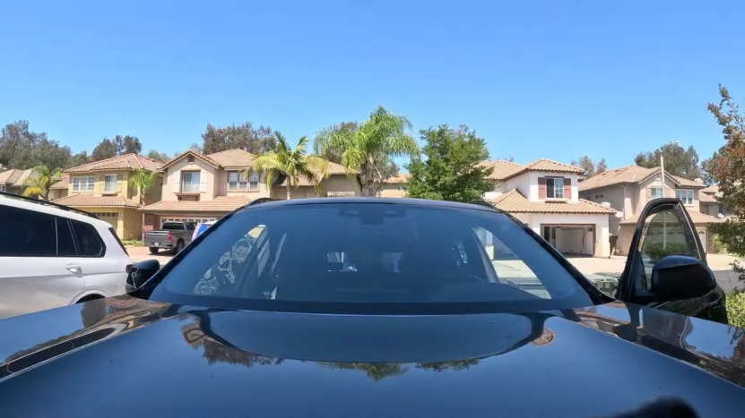 A Black BMW Parked in Front of Suburban Houses with A Newly Installed Windshield