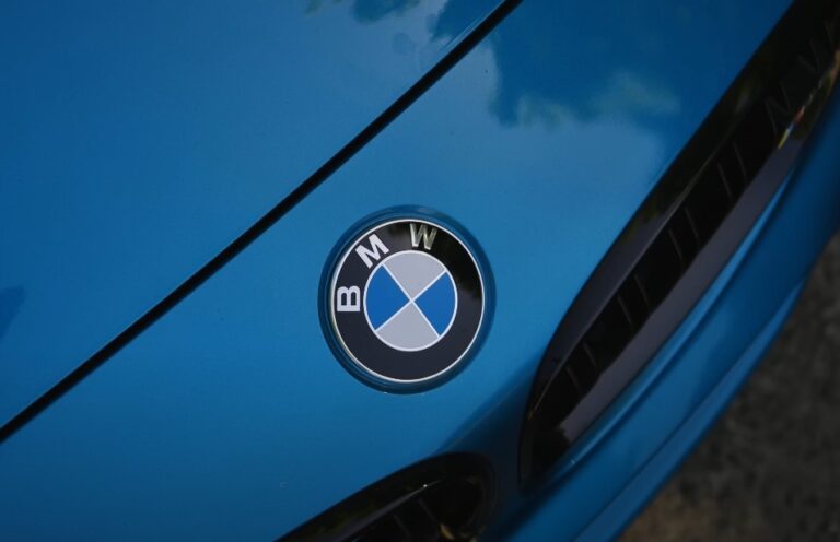 Close up photo of a BMW logo on a blue hood