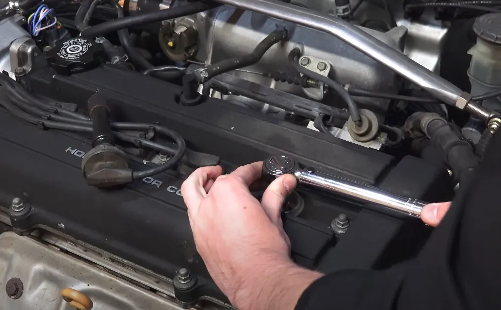 Man holding a wrench while fixing a car