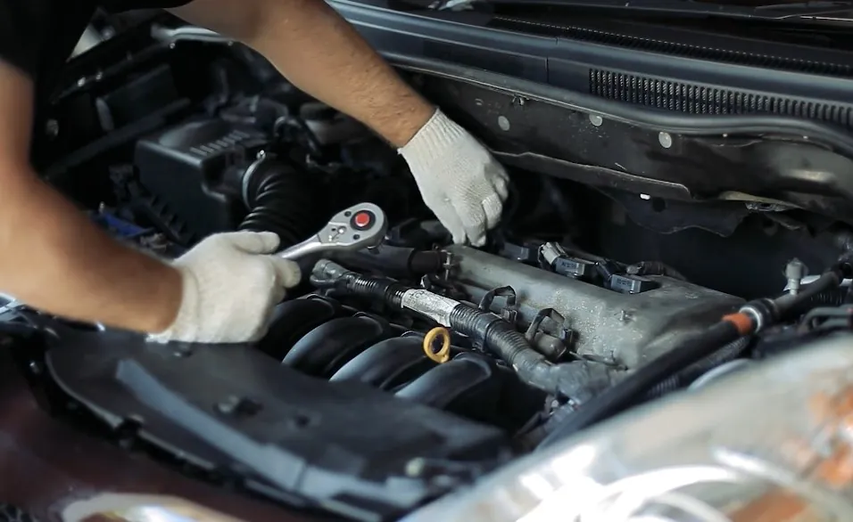 Mechanic repairing car's under the hood parts