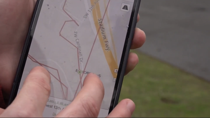 Close-Up of A Hand Using a Smartphone GPS Map to Track a Vehicle's Location