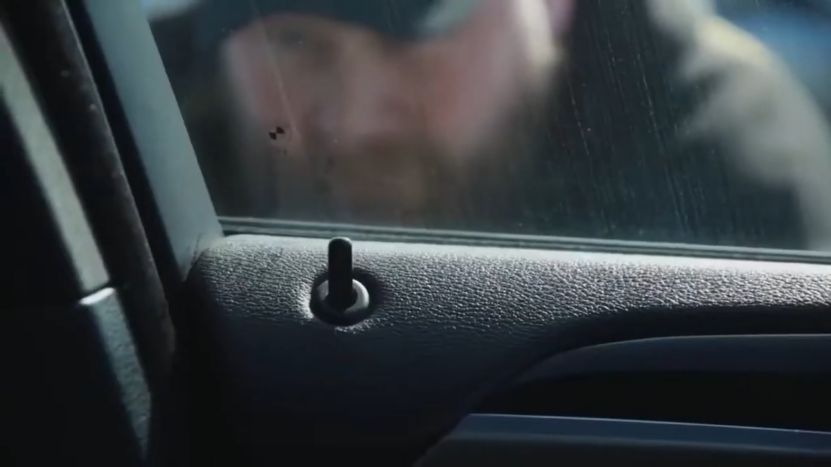 Close-Up View of A Person Peering Through a Car Window, Suggesting a Possible Theft Attempt