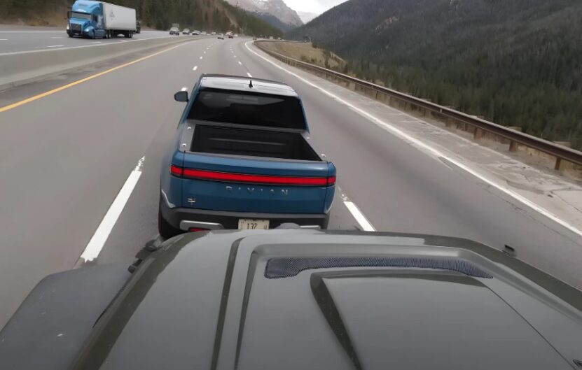 Rivian R1T truck towing a trailer, pictured from behind