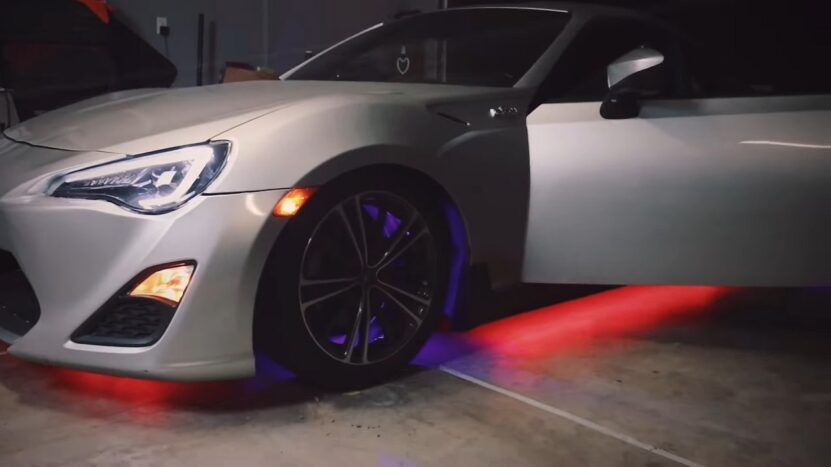 Underbody lighting that glows red and blue in a dimly lit garage